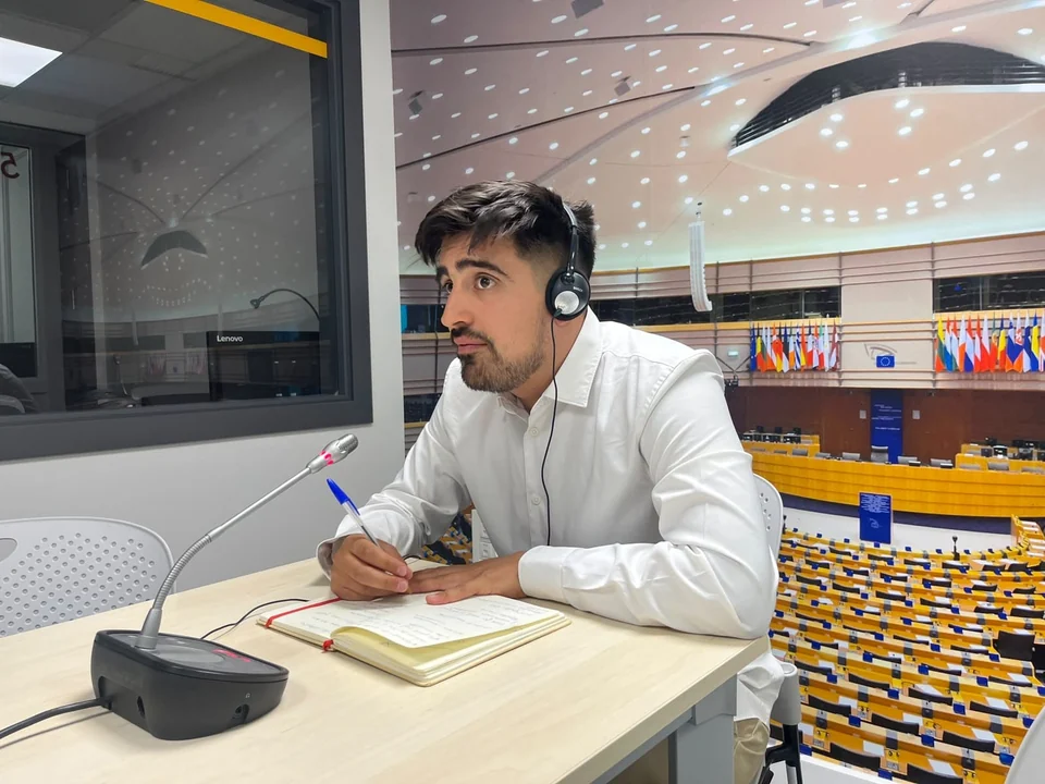 Lincoyan Parada en una cabina de interpretación con micrófono y libreta
