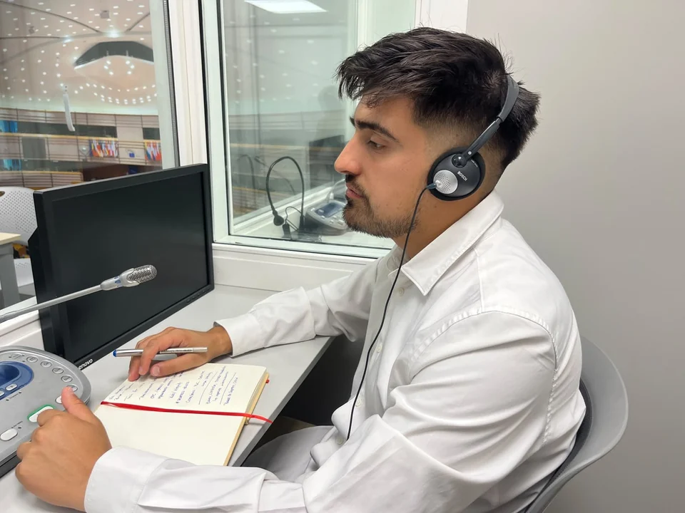 Lincoyan Parada escuchando con auriculares, micrófono y notas a mano